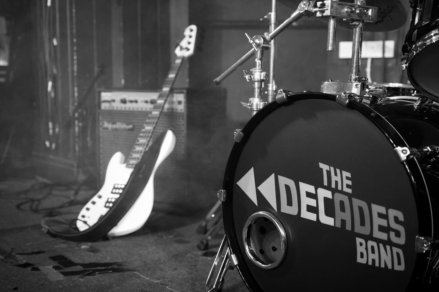 The Decades Band stage showing drum kit and guitar